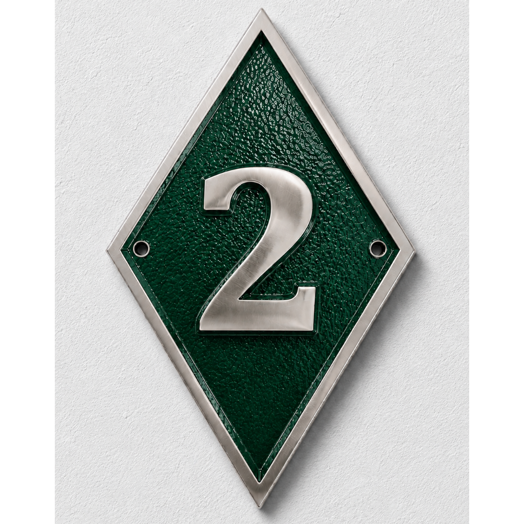 A diamond-shaped green house number plaque with a silver metallic border and the number '2' in raised silver lettering, mounted on a light gray textured wall.