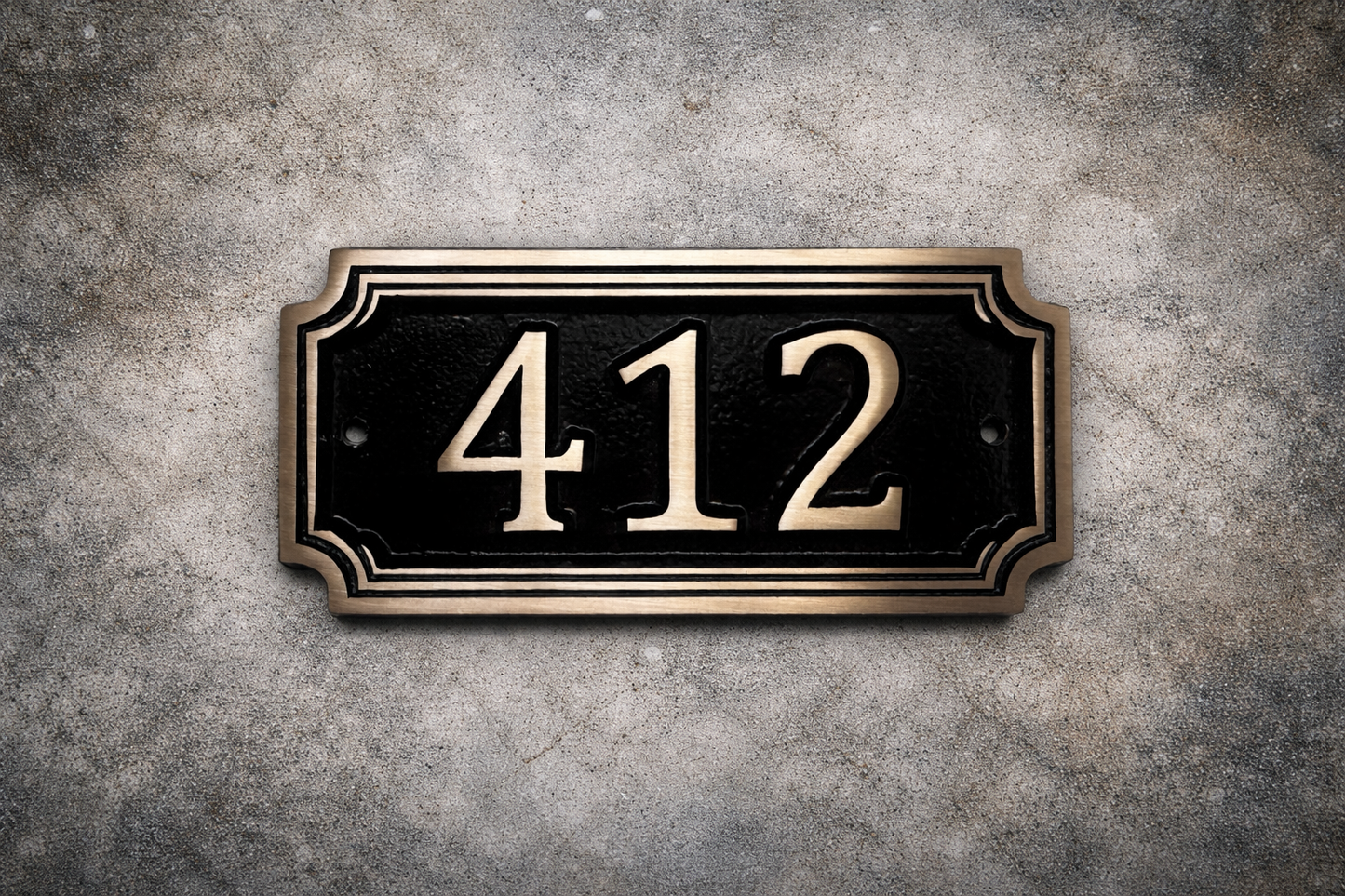 Cast bronze rectangle house number sign with raised numbers and double border mounted on exterior wall