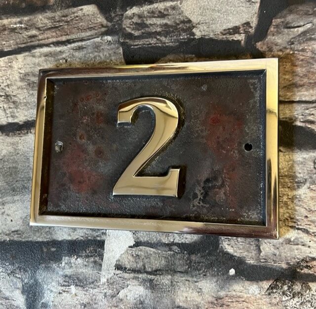 house number sign in aluminium patina background