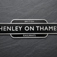 A vintage-style British Henley on Thames Railways sign with white lettering on a black background, mounted on a dark textured slate surface.