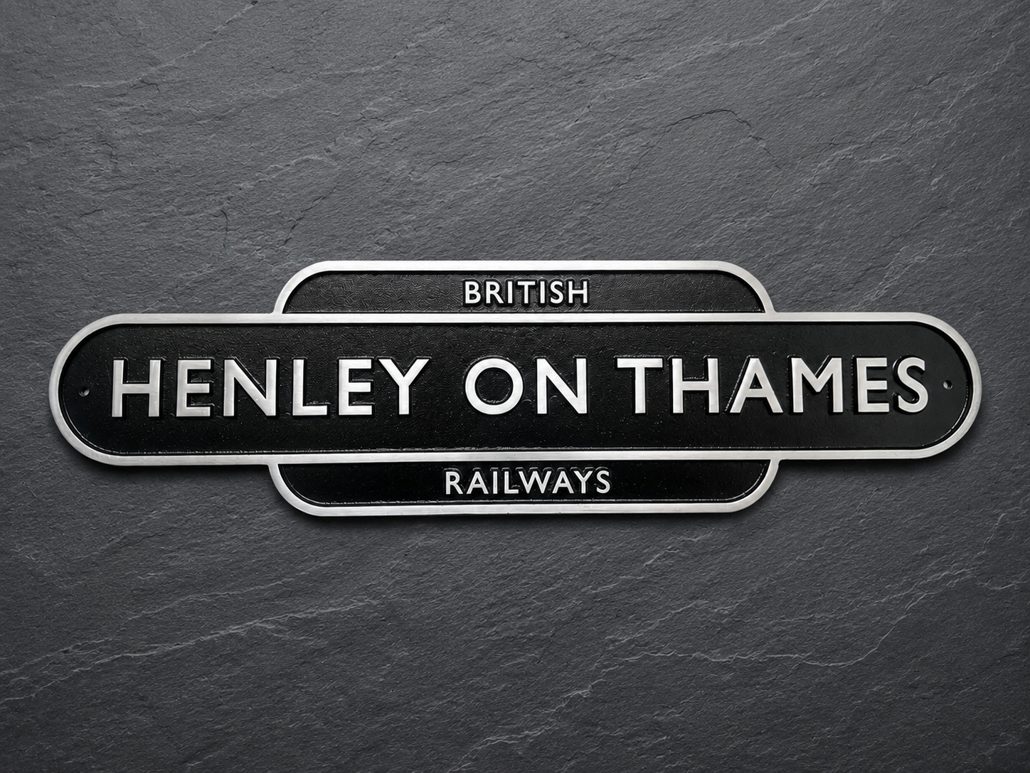 A vintage-style British Henley on Thames Railways sign with white lettering on a black background, mounted on a dark textured slate surface.