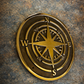 Cast bronze compass wall plaque with raised compass rose detail mounted on exterior wall