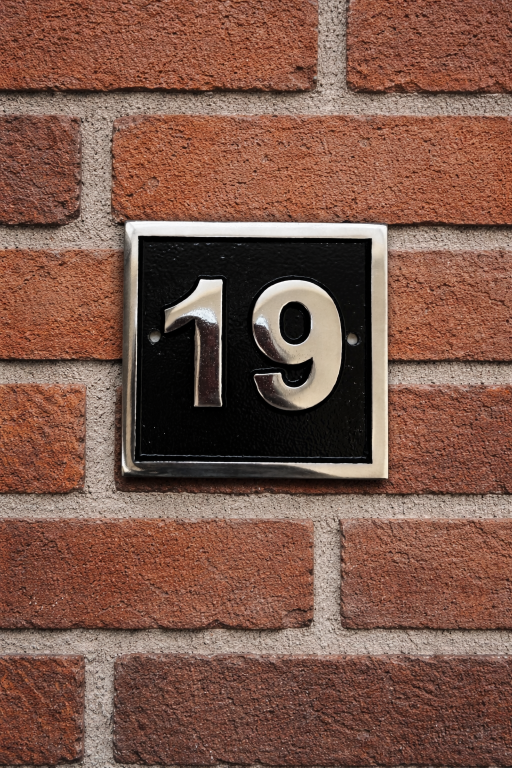 Cast aluminium square house number sign with raised polished numerals black background and background fixing holes