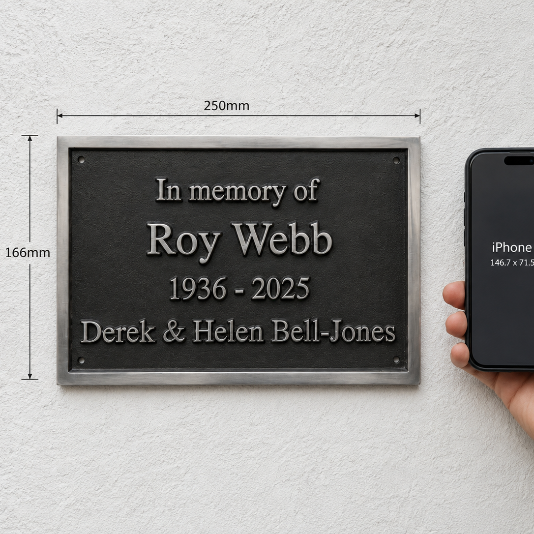 A memorial wall plaque with engraved silver text on a dark plaque, shown mounted on a white textured wall next to a hand holding an iPhone 14 to indicate scale. The image includes dimension lines showing the plaque's size as 250mm by 166mm.