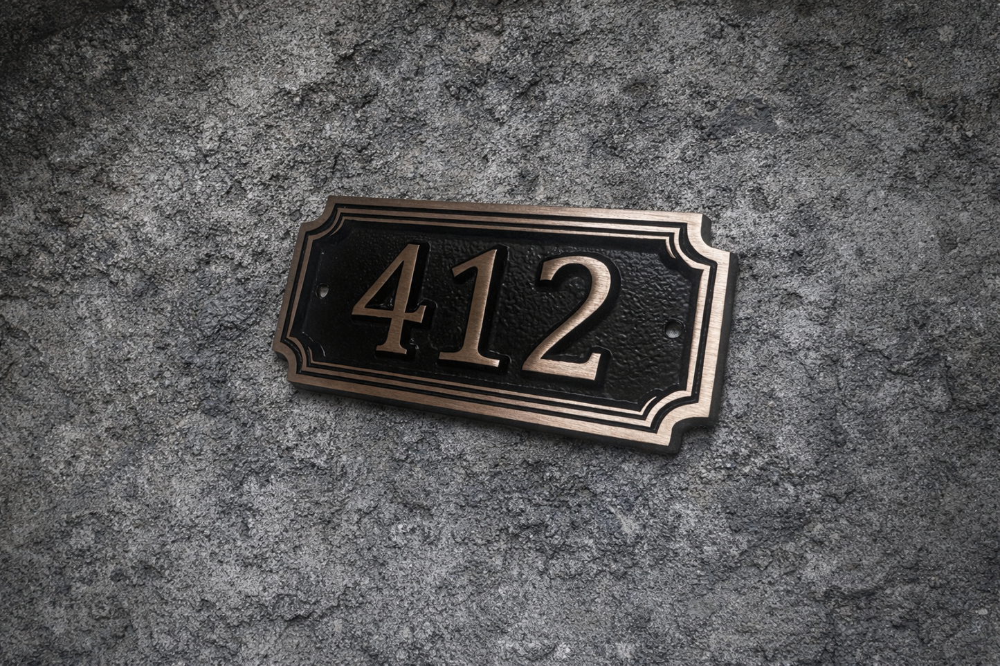 Cast bronze rectangle house number sign with raised numbers and double border mounted on exterior wall