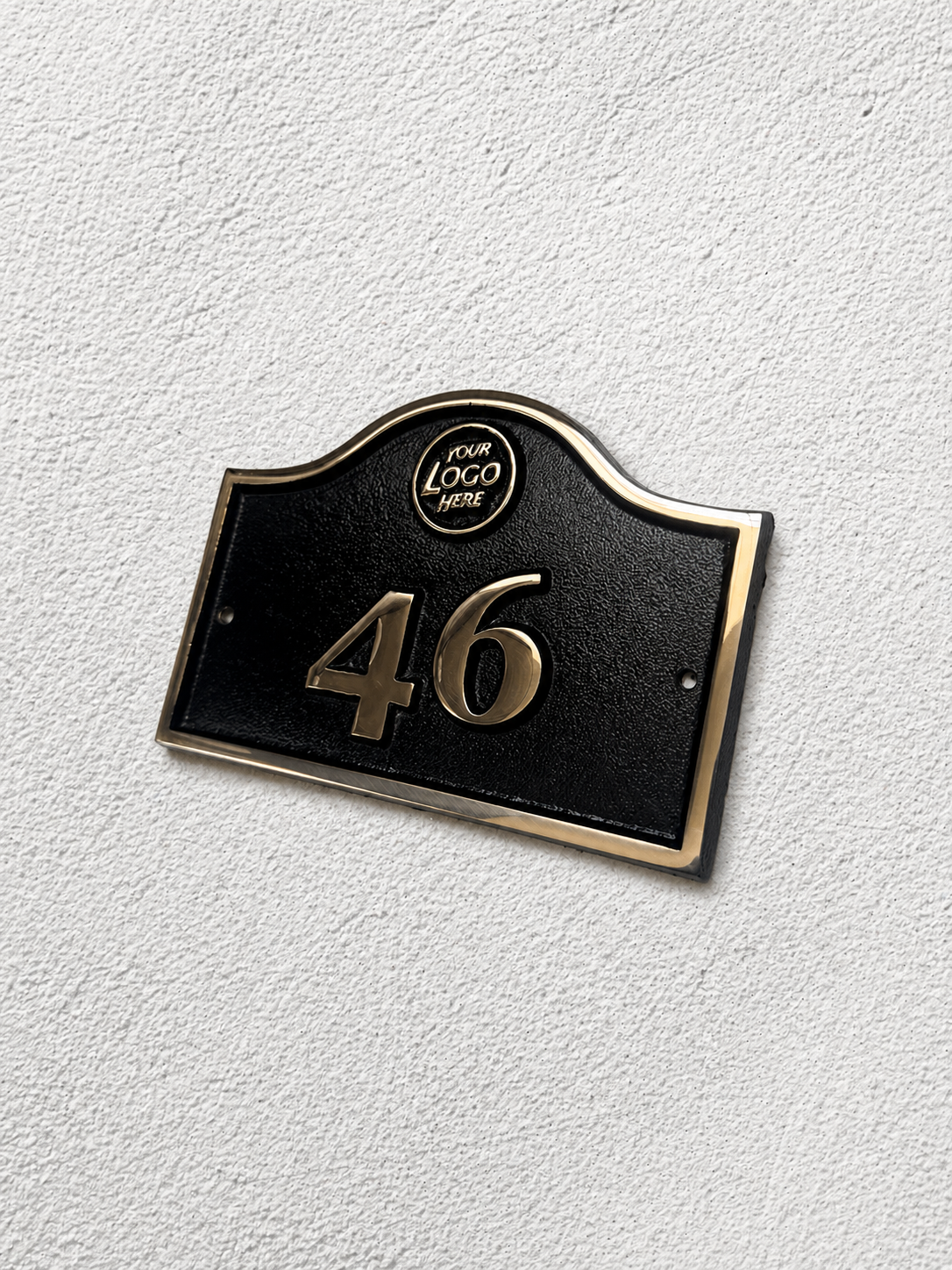 Cast bronze hotel room number sign with custom logo and raised numbers mounted on wall