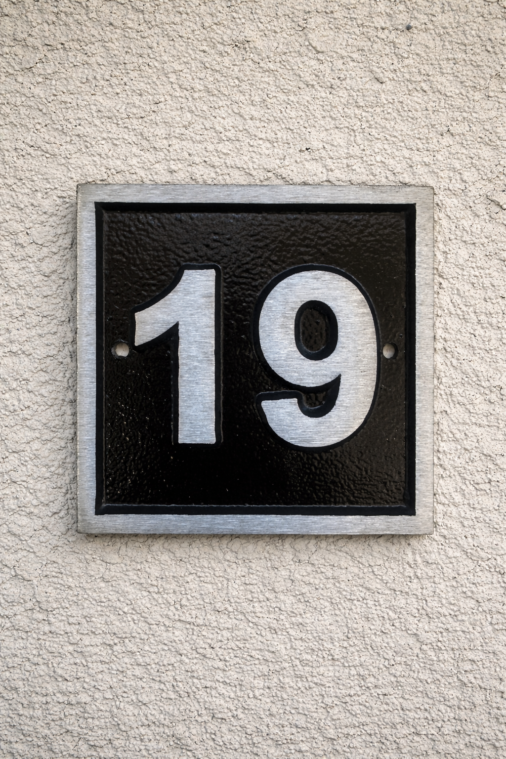 Cast aluminium square house number sign with raised brushed numerals black background and background fixing holes