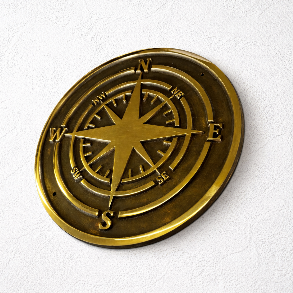 Cast bronze compass wall plaque with raised compass rose detail mounted on exterior wall