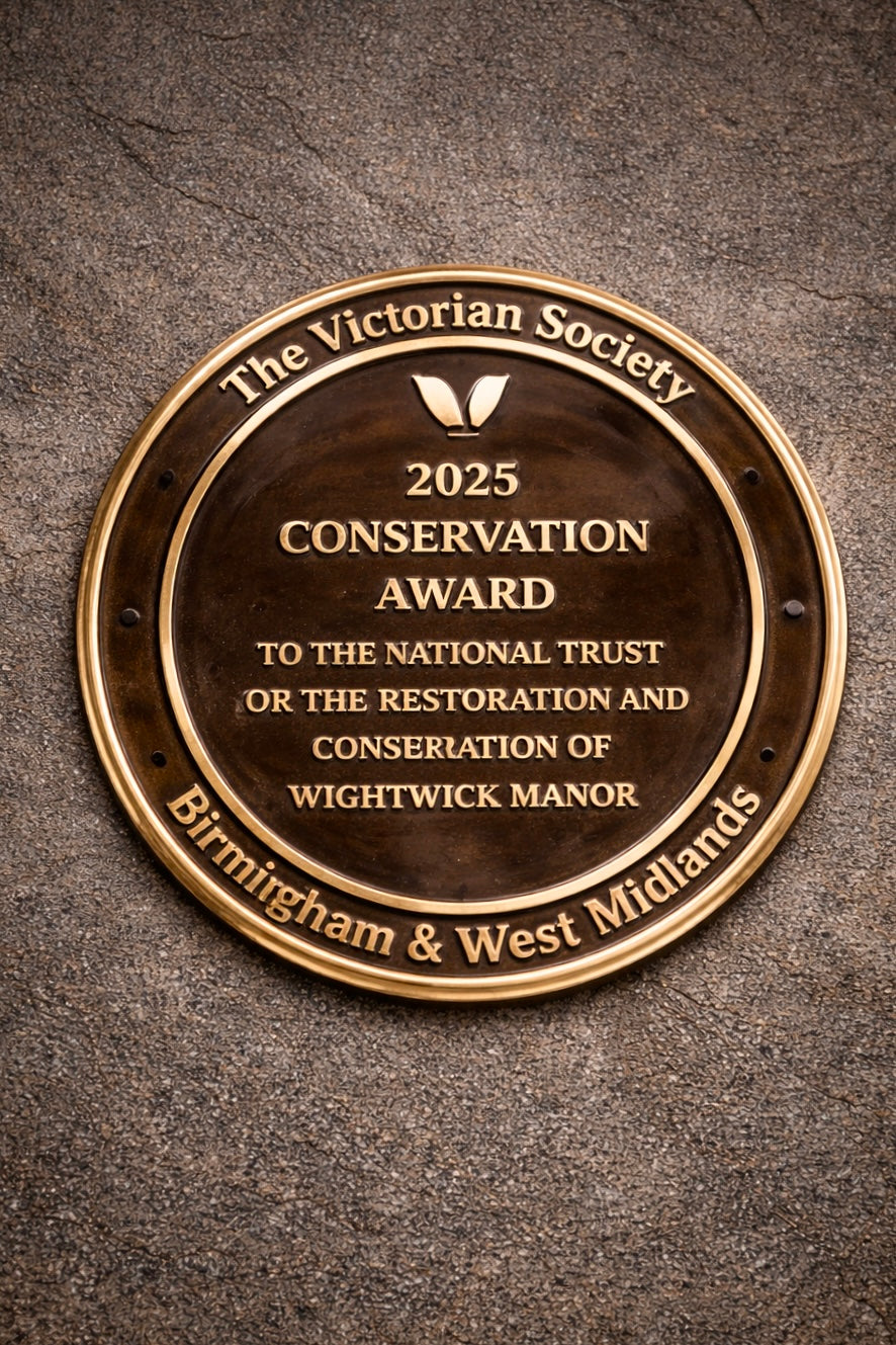 Cast bronze circular heritage plaque with raised lettering mounted on exterior wall