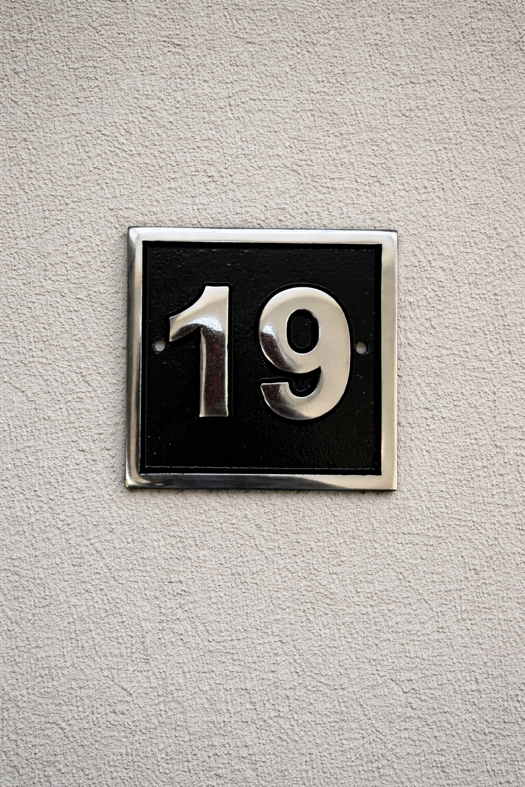 Cast aluminium square house number sign with raised polished numerals black background and background fixing holes