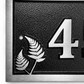 Personalised cast aluminium house number plaque featuring satin-finished number 45 with decorative fern motif and black textured background.