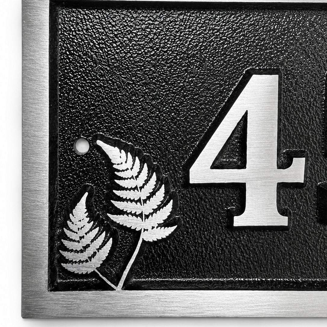 Personalised cast aluminium house number plaque featuring satin-finished number 45 with decorative fern motif and black textured background.