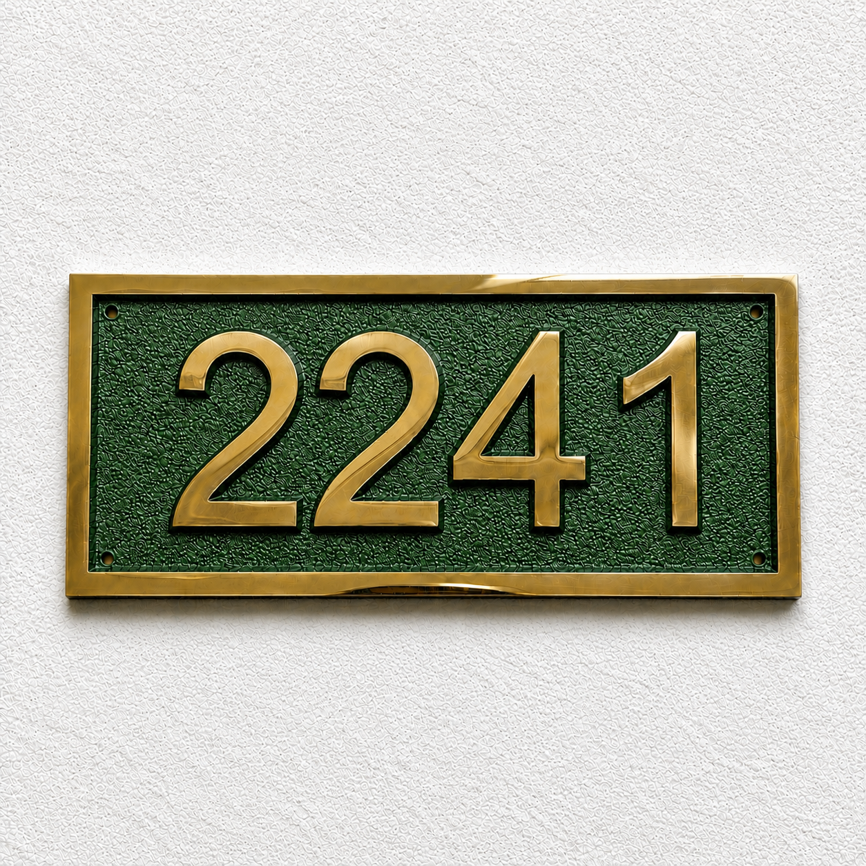 A rectangular house number plaque with raised gold numerals '2241' on a textured dark green background, mounted on a white textured wall.