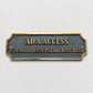 ADA Access sign with gold lettering on a textured dark gray plaque, mounted on a white textured wall.