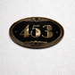 Art Deco bronze house number plaque oval with raised numbers mounted on wall