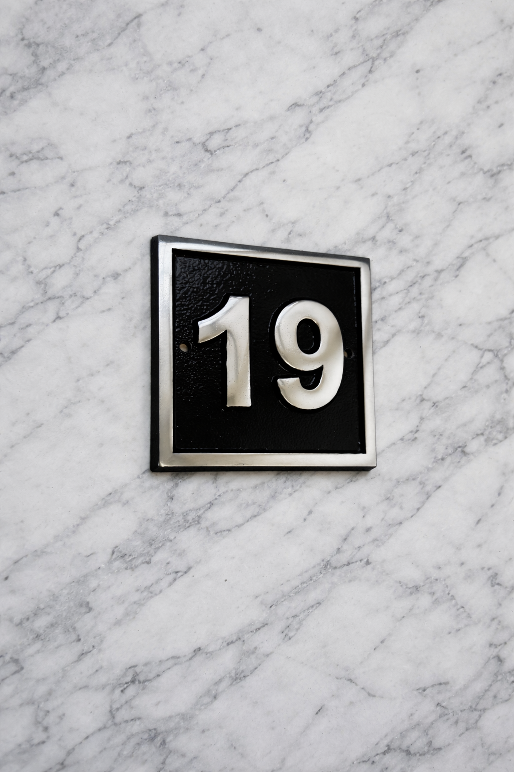 Cast aluminium square house number sign with raised polished numerals black background and background fixing holes
