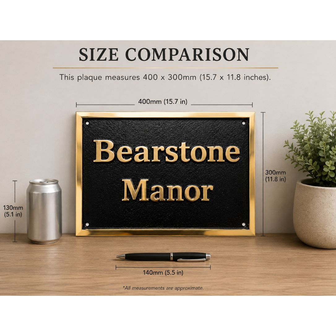 A black rectangular plaque with gold lettering reading 'Bearstone Manor' is shown on a tabletop with overlaid size measurements comparing it to a soda can and pen. The image includes the text 'SIZE COMPARISON' and dimensions for the plaque.