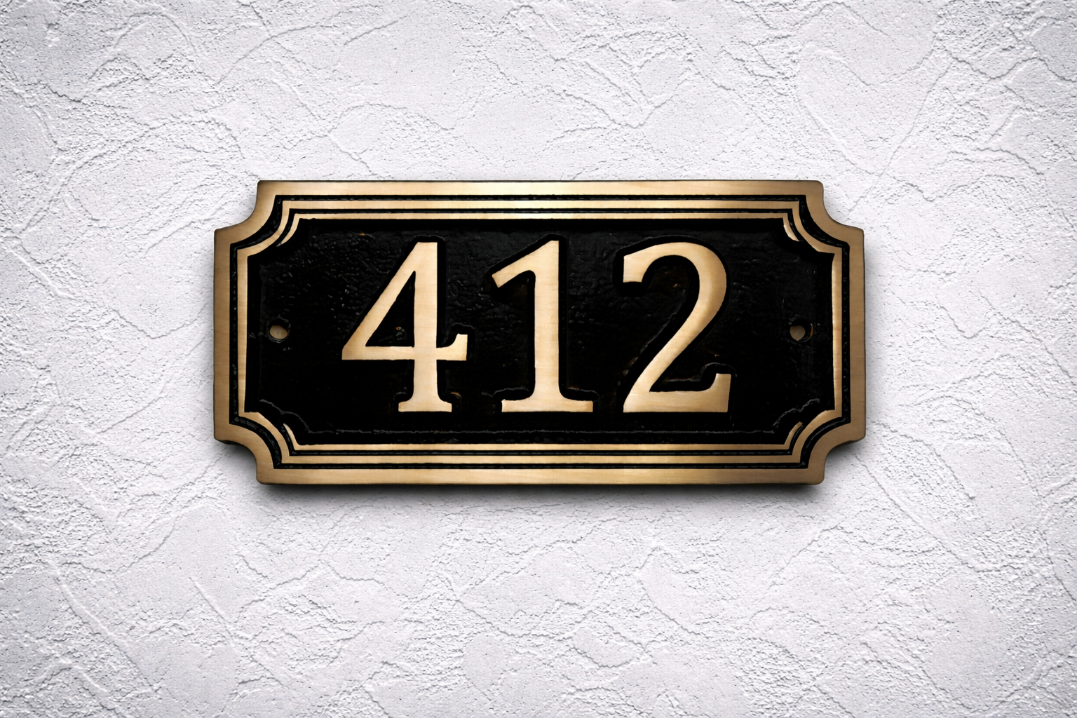 Cast bronze rectangle house number sign with raised numbers and double border mounted on exterior wall