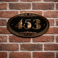Close up of cast bronze number sign showing textured background and polished numerals