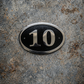 Cast aluminium oval house number sign with raised numerals and border