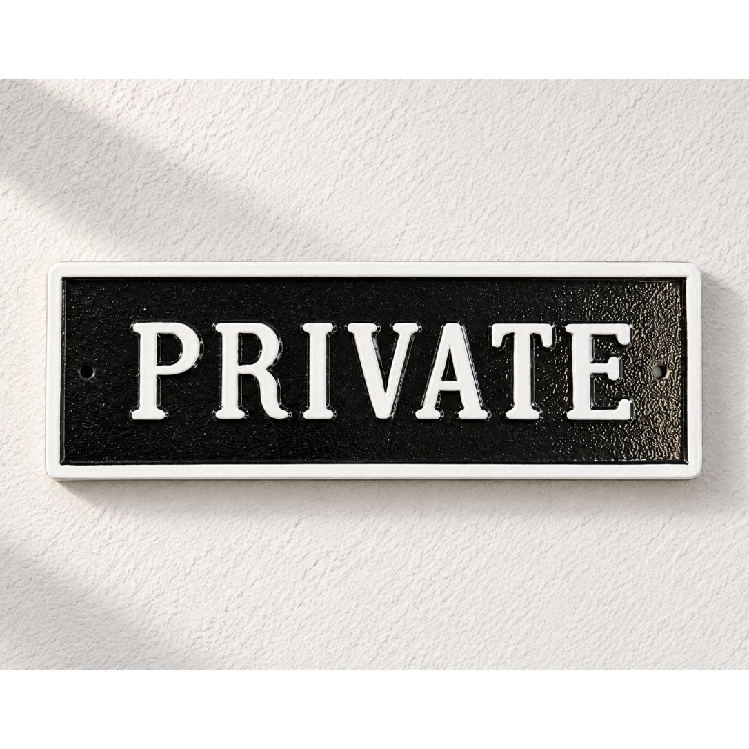 A rectangular black sign with a white border and the word 'PRIVATE' in large white serif letters, mounted on a textured white wall.