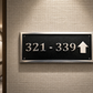 Cast aluminium directional sign with custom text and arrow for hotel or office wayfinding