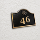 Cast bronze hotel room number sign with custom logo and raised numbers mounted on wall