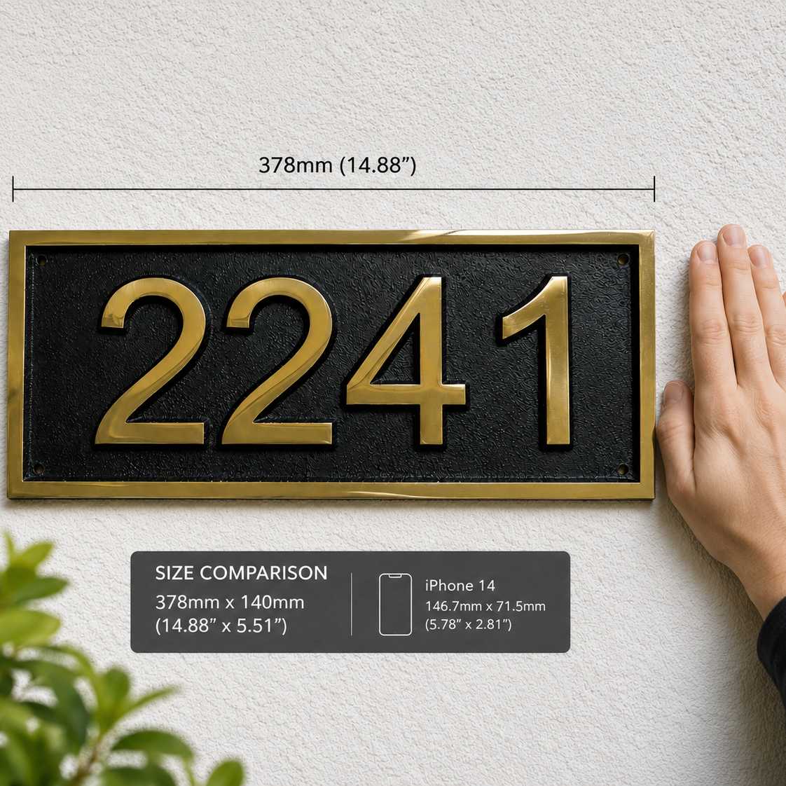 A house number plaque reading 2241 in raised gold numerals on a black rectangular face with a gold border, mounted on a textured white wall. Measurement annotations show 378mm by 140mm, and a hand holds the right side for scale.