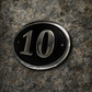 Cast aluminium oval hotel room number sign with raised numbers and black background mounted on wall