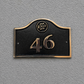 Cast bronze hotel room number sign with custom logo and raised numbers mounted on wall