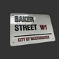 Metallic street sign replica of Baker Street W1 with 'City of Westminster' text on a dark background