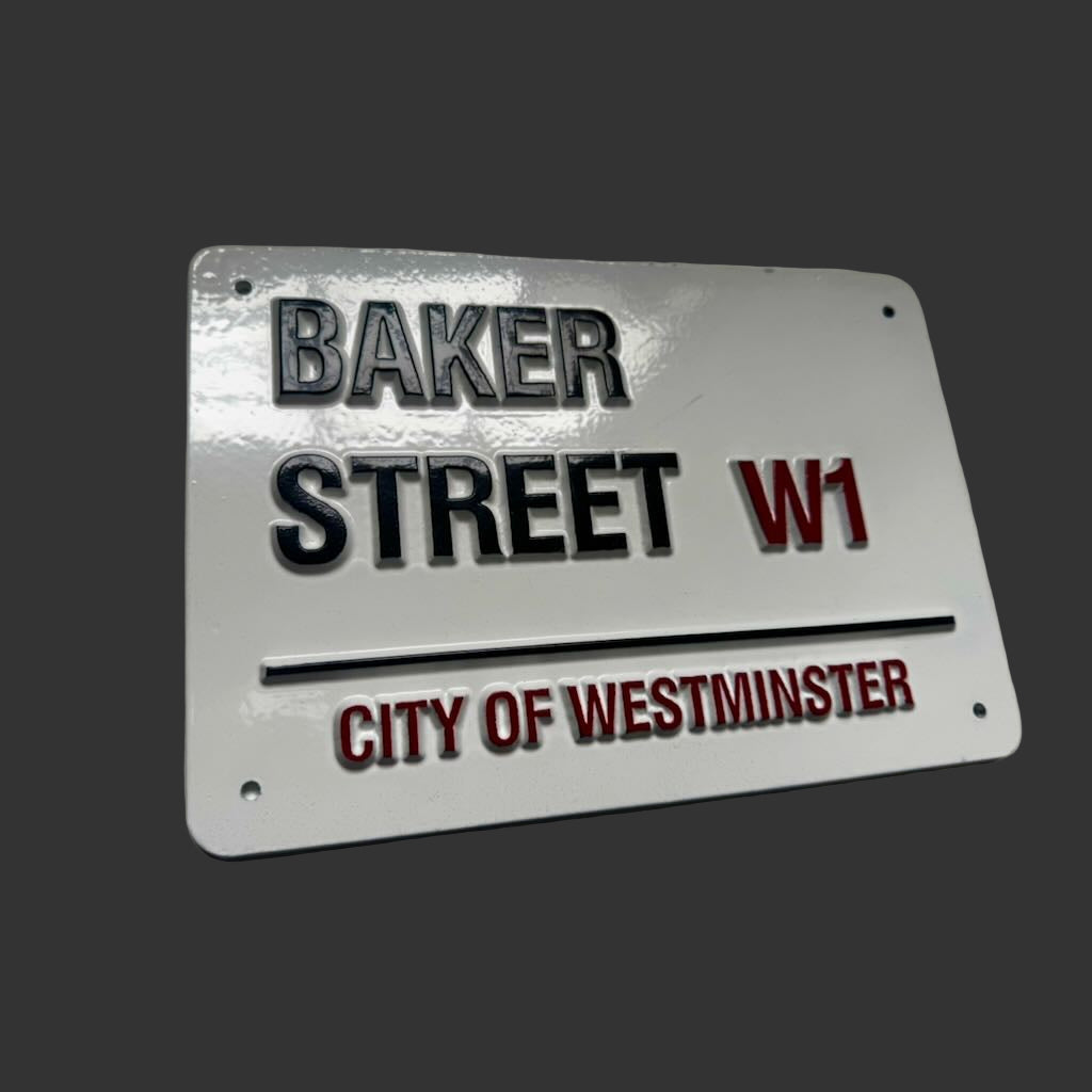 Metallic street sign replica of Baker Street W1 with 'City of Westminster' text on a dark background