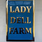 Blue sign with gold text 'LADY DELL FARM' on a blue background
