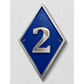 A diamond-shaped blue house number plaque with a silver metallic border and the number '2' in raised silver lettering, mounted on a textured white wall.