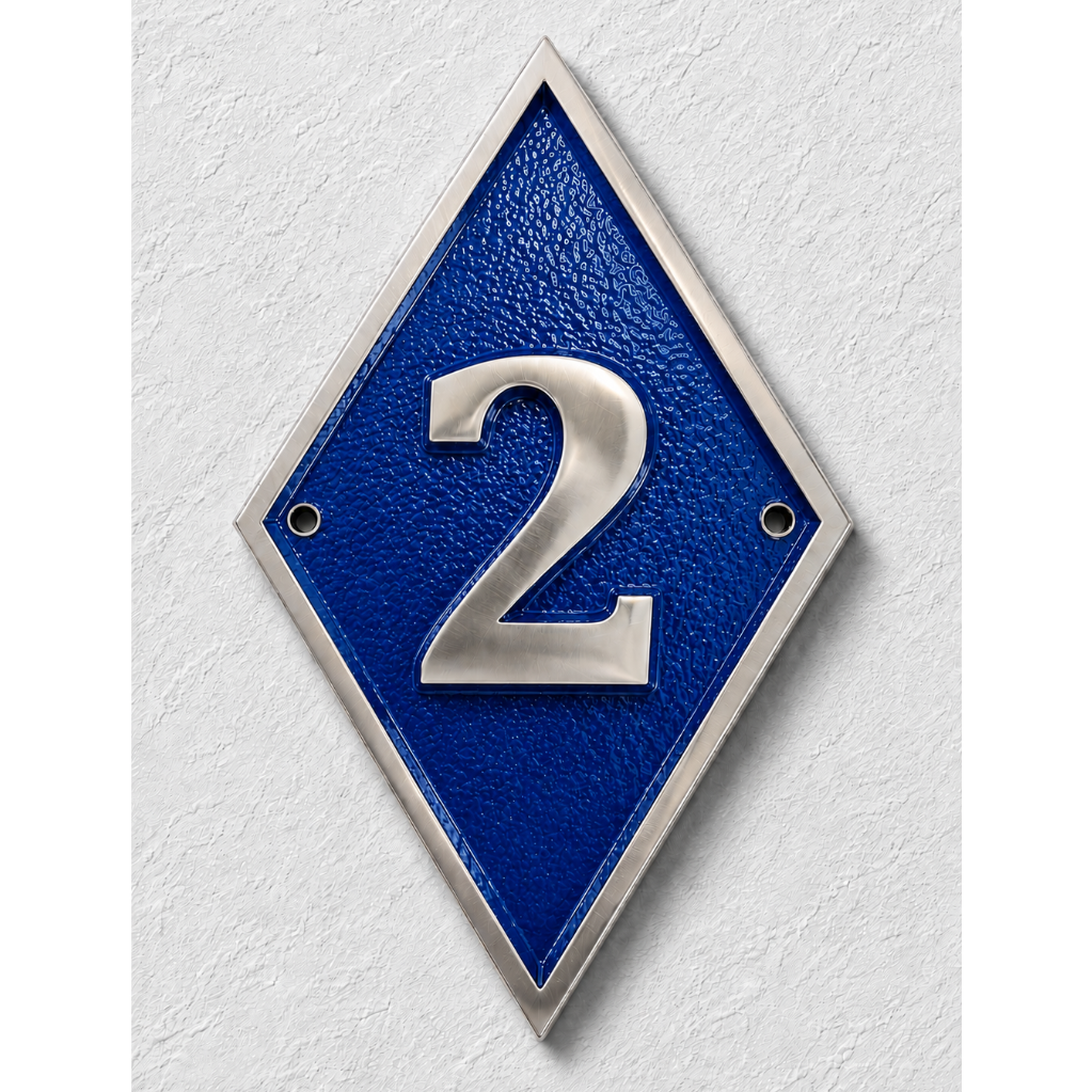 A diamond-shaped blue house number plaque with a silver metallic border and the number '2' in raised silver lettering, mounted on a textured white wall.