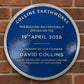 Modern blue heritage plaque with brushed silver border and raised lettering mounted on exterior wall