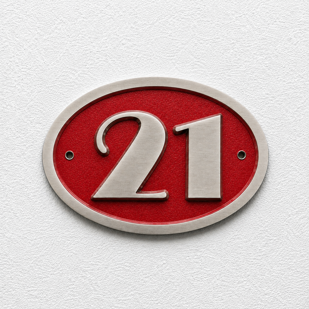 An oval house number plaque featuring the number 21 in raised silver lettering on a textured red background, mounted on a white textured wall.