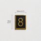 Gold house number 8 plaque on a black background, mounted on a textured white wall with dimension lines showing 130mm width and 140mm height.