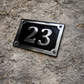 Cast aluminium rectangle house number sign with polished raised numbers and decorative border