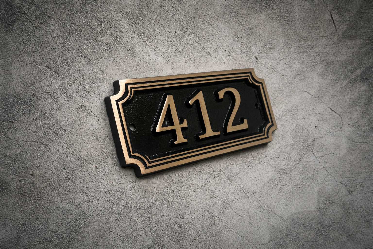 Cast bronze rectangle house number sign with raised numbers and double border mounted on exterior wall