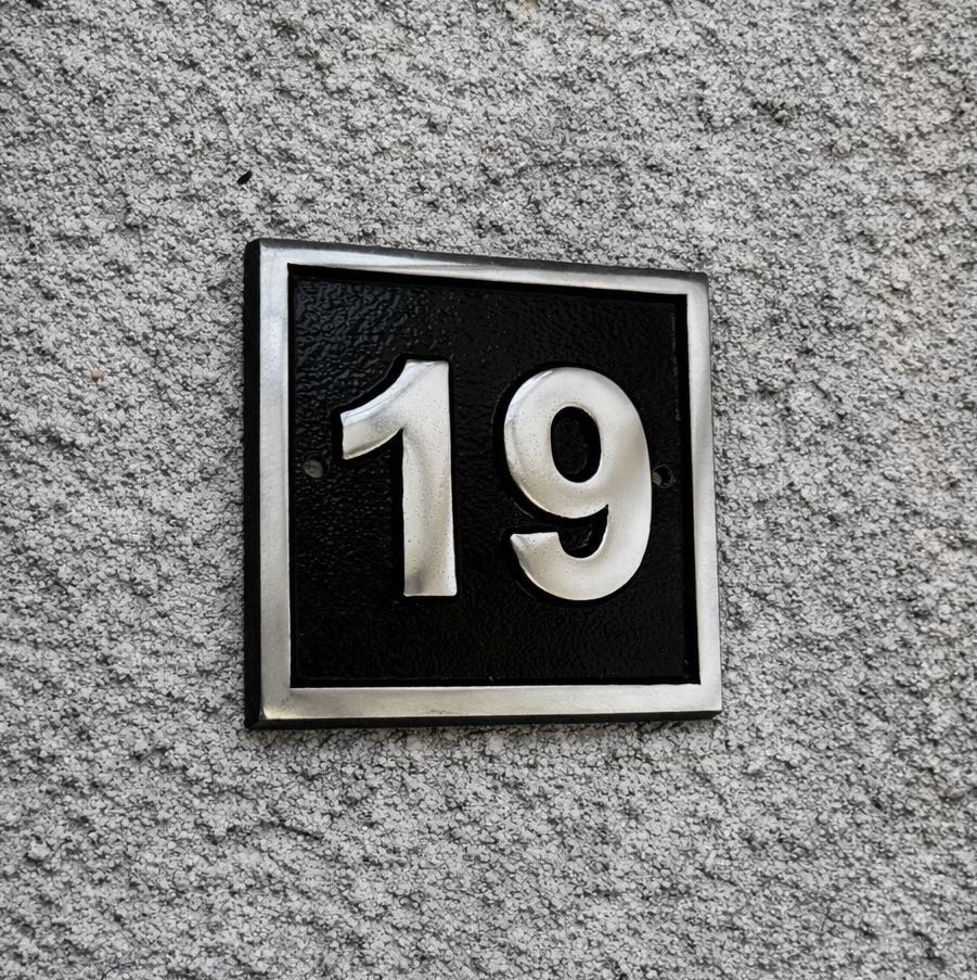 Cast aluminium square house number sign with raised polished numerals black background and background fixing holes