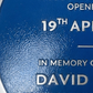 Modern blue heritage plaque with brushed silver border and raised lettering mounted on exterior wall