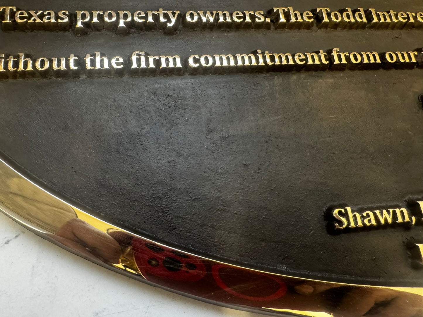 Close-up of a metallic plaque with engraved text on a reflective surface.