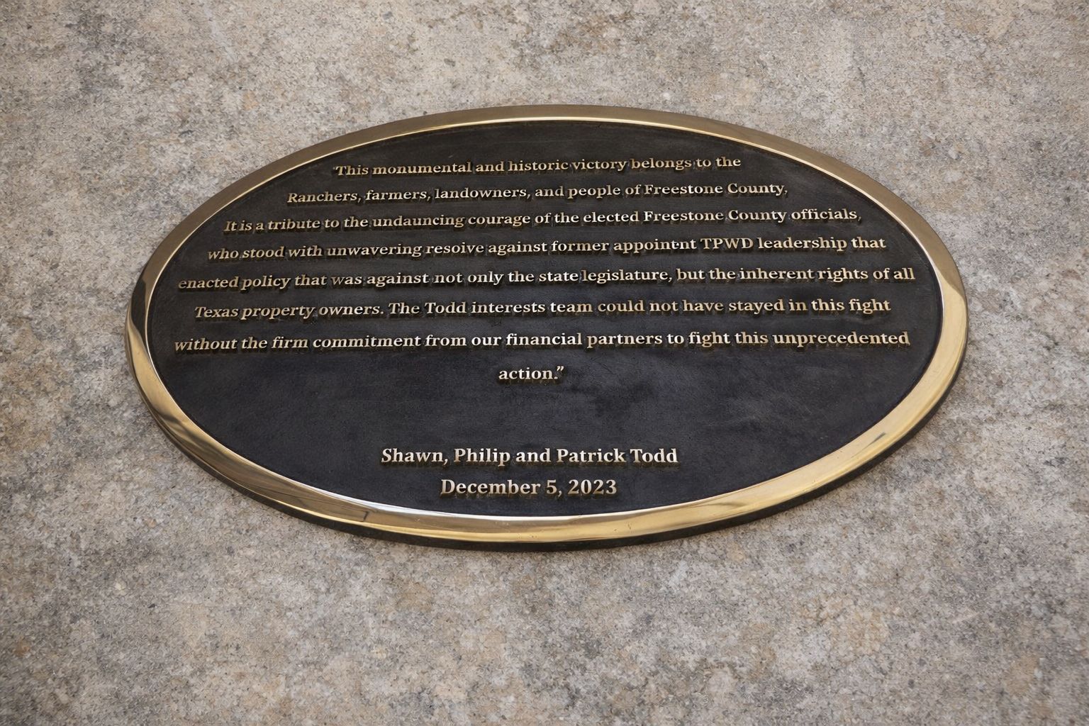 Plaque with engraved text on a concrete surface