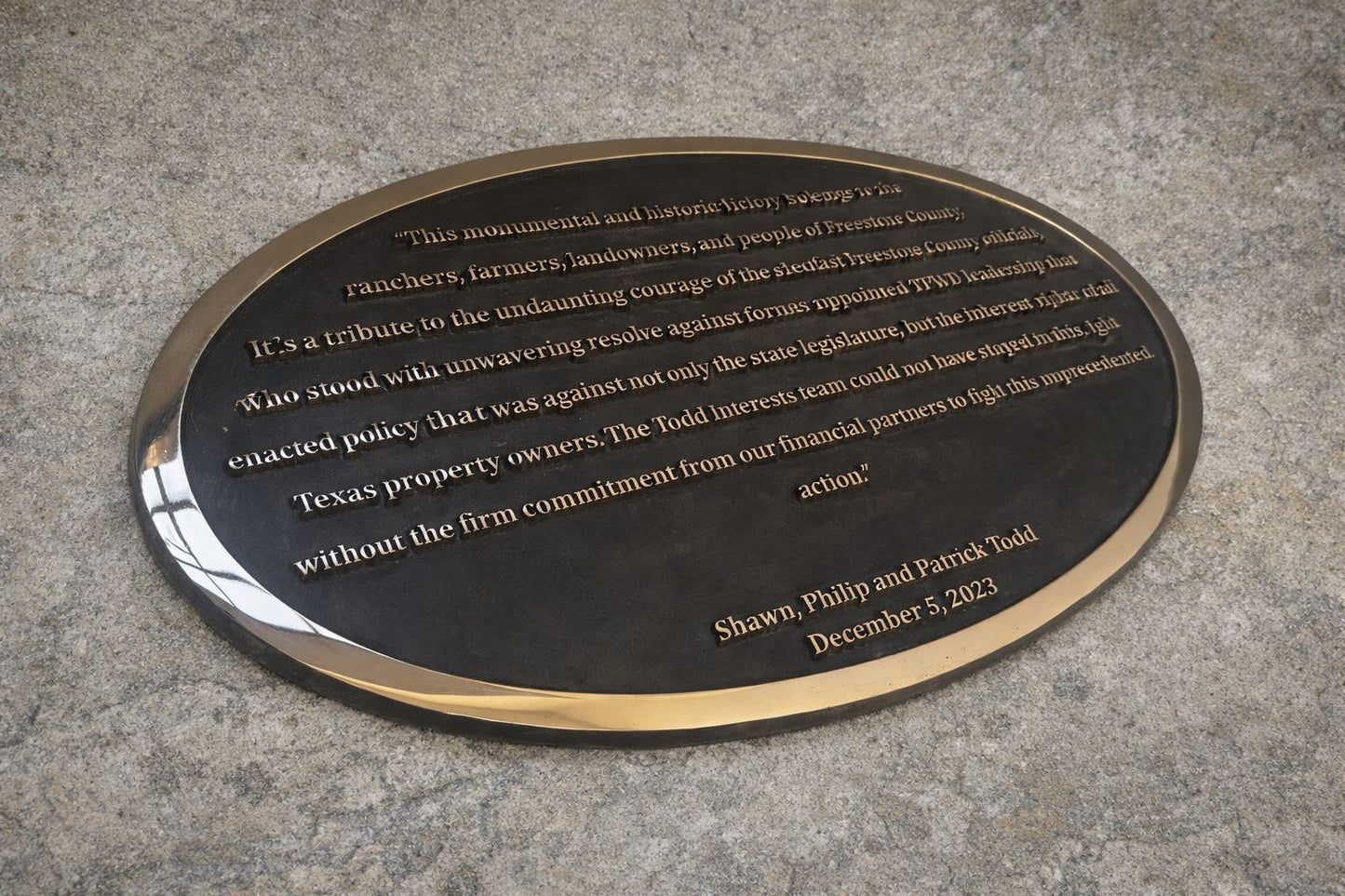 Plaque with engraved text on a concrete surface