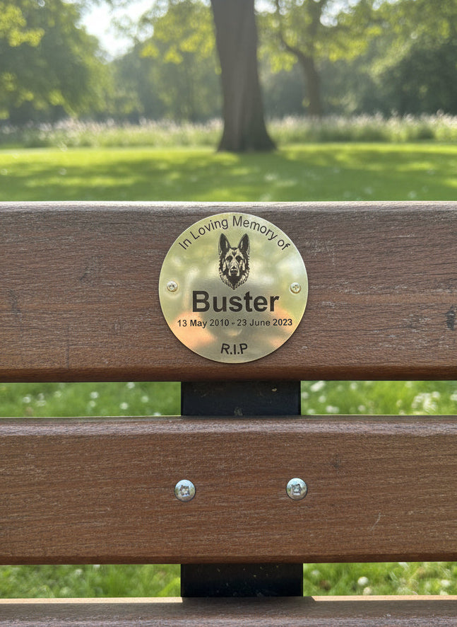 Gold plate with dog's name and lifespan on a white wall