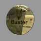 Gold plaque with a dog's face and text 'In Loving Memory of Buster' on a gray background