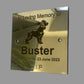 Gold plaque with engraved dog illustration and text 'In Loving Memory of Buster' on a gray background