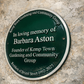 Close-up of cast aluminium green heritage plaque showing raised lettering detail
