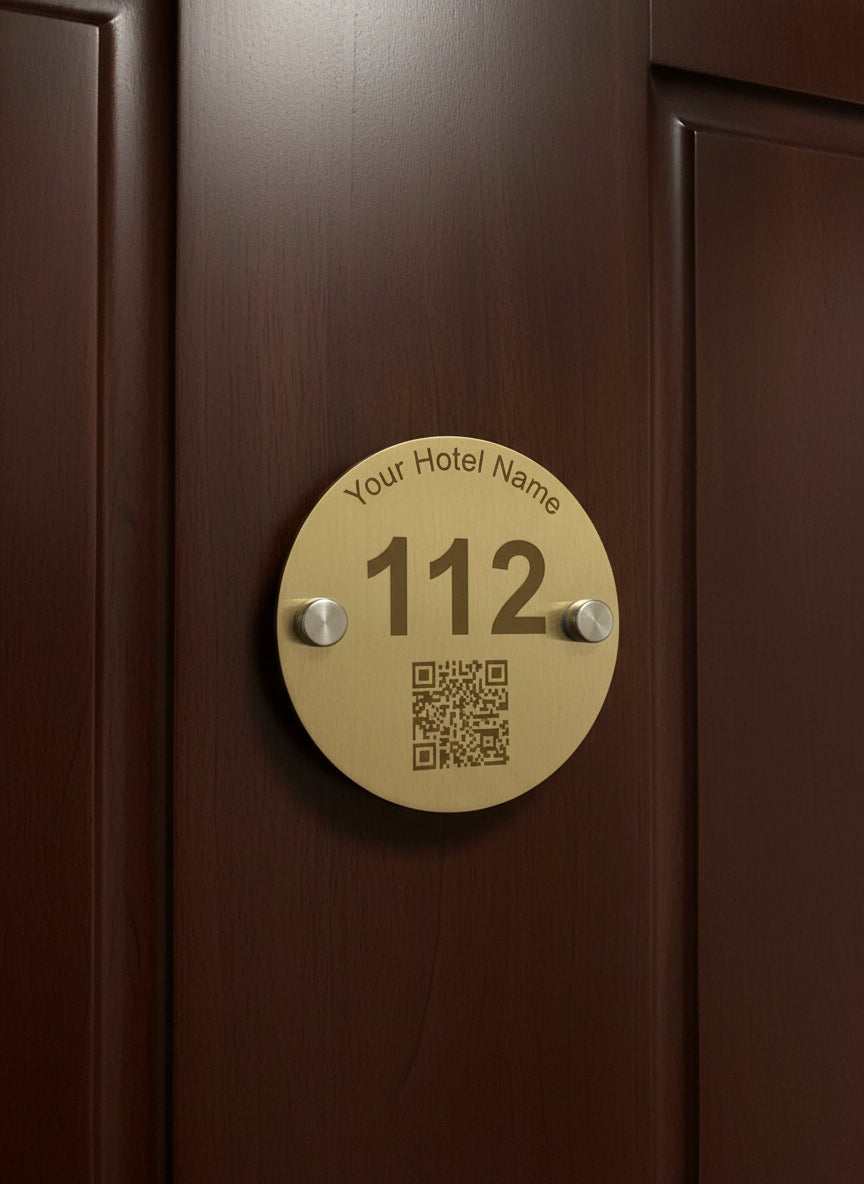 Brass hotel room number sign with QR code on a white background